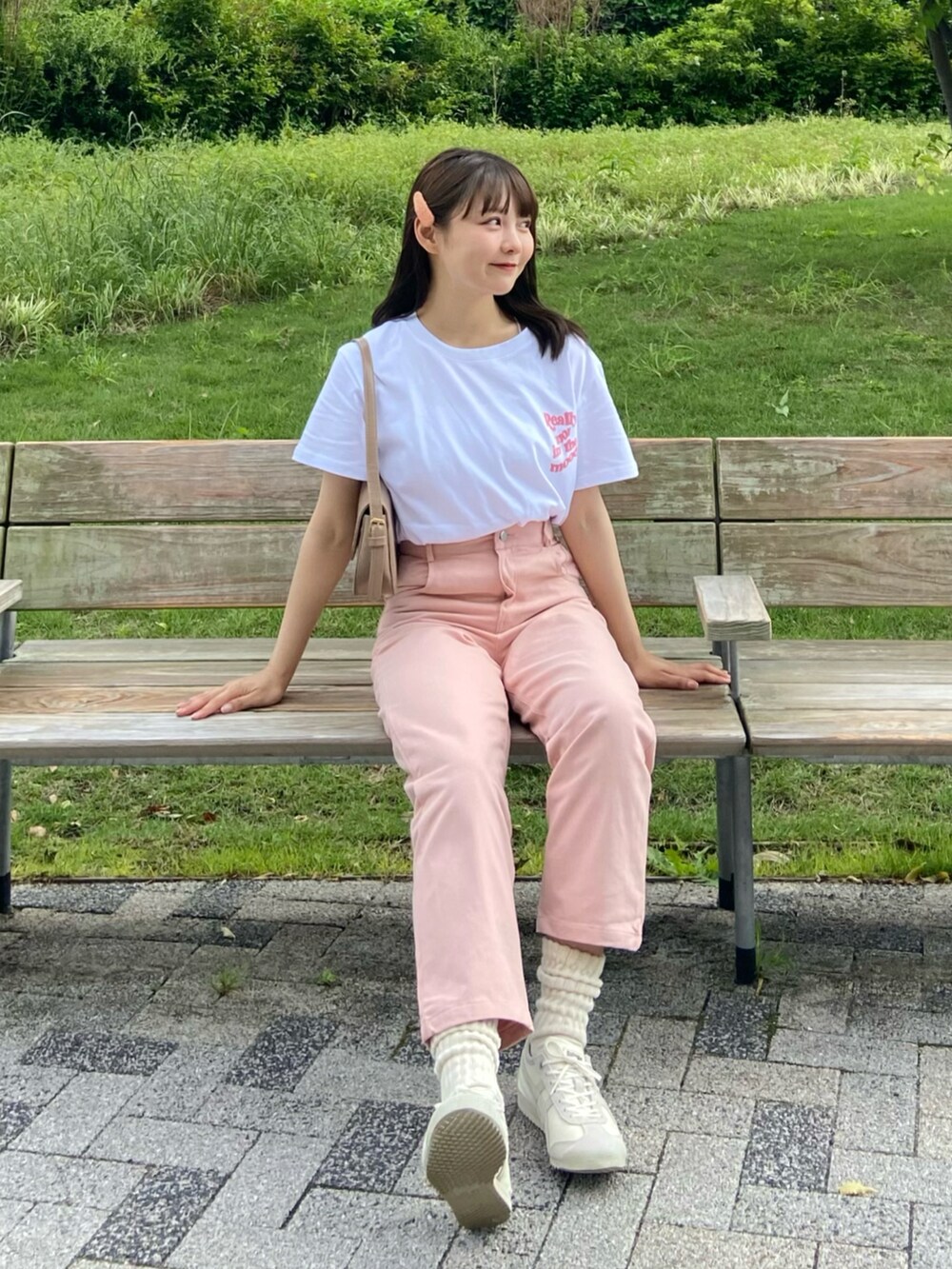 ホワイト系のTシャツ/カットソー、ベージュ系のハンドバッグ、ピンク系のパンツを着用したレディースの夏コーディネートの2枚目の写真