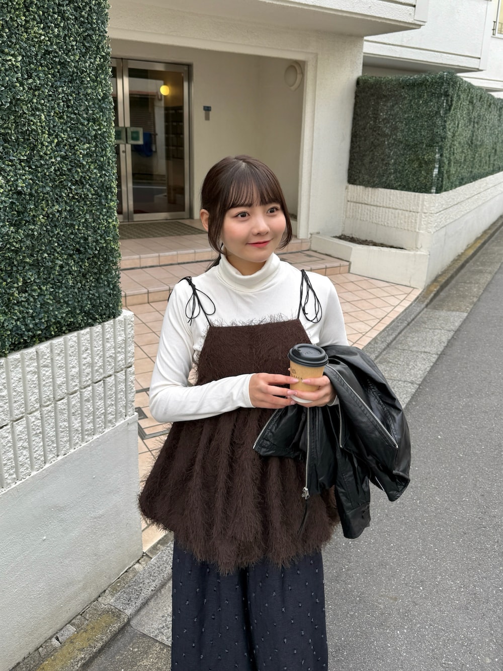 ブラウン系のキャミソール、ホワイト系のニット/セーター、ブラック系のブルゾンを着用したレディースの秋コーディネートの3枚目の写真