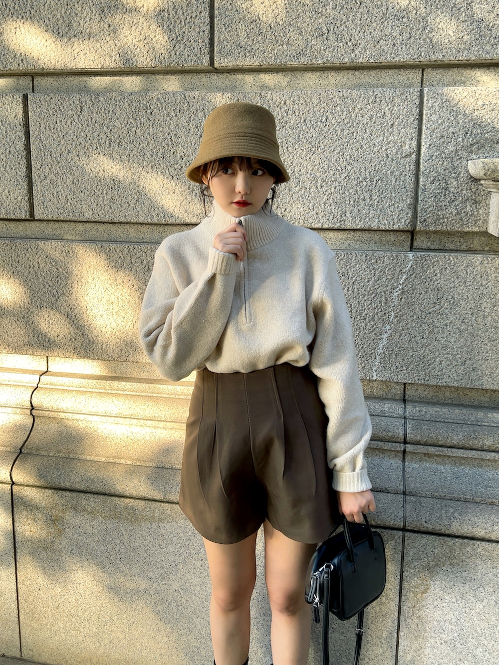 ホワイト系のブルゾン、ベージュ系のニット/セーター、ブラウン系のその他パンツを着用したレディースの冬コーディネートの3枚目の写真