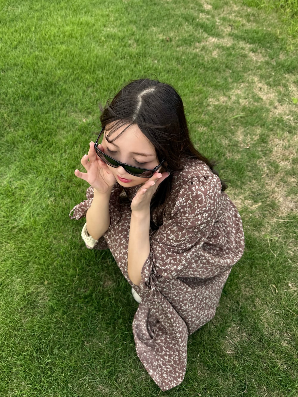 ブラウン系のワンピース、ホワイト系のサンダル、ホワイト系のかごバッグを着用したレディースの夏コーディネートの3枚目の写真