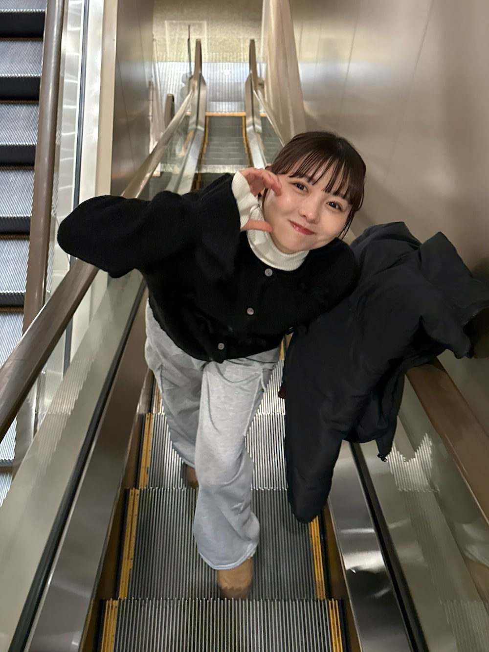 ブラック系のニット/セーター、ホワイト系のニット/セーター、レッド系のボストンバッグを着用したレディースの冬コーディネートの4枚目の写真