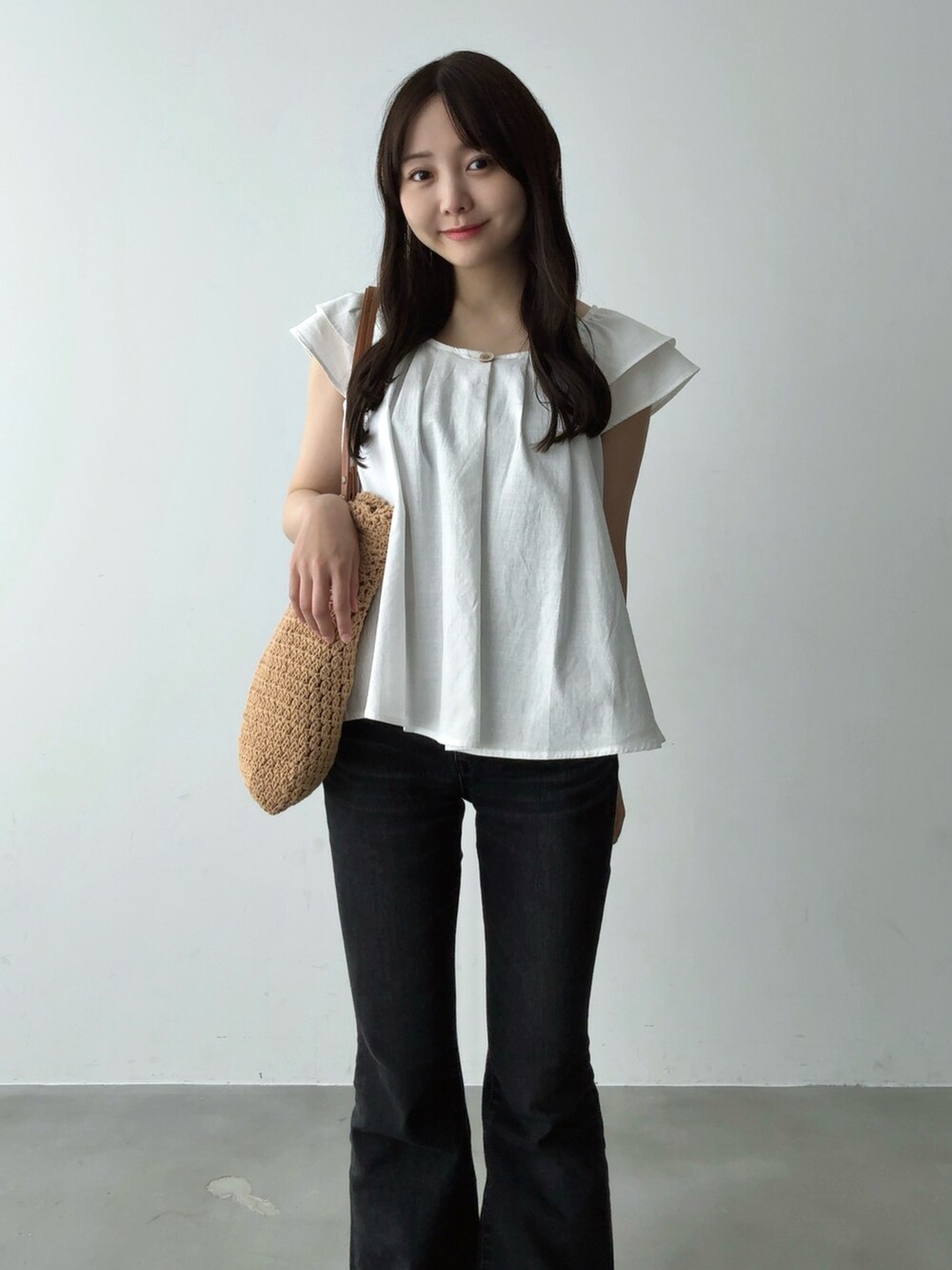 ホワイト系のシャツ/ブラウス、ブラウン系のトートバッグ、ブラック系のデニムパンツを着用したレディースの夏コーディネートの4枚目の写真