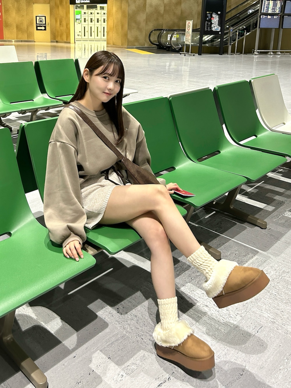 ブラウン系のスウェット、ホワイト系のその他パンツ、イエロー系のブーツを着用したレディースの秋コーディネートの2枚目の写真