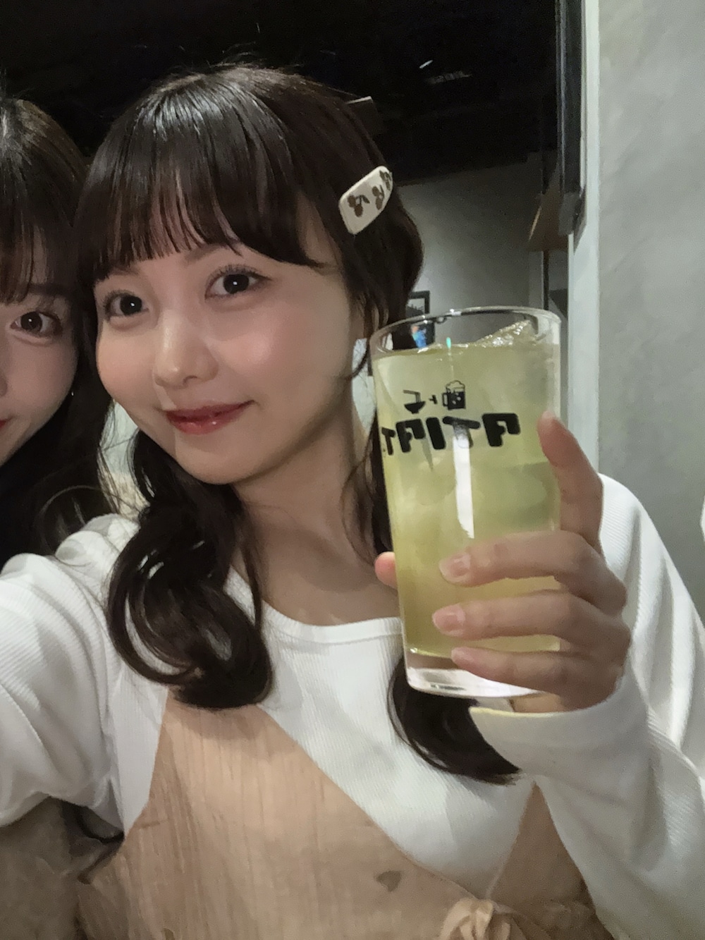 ピンク系のキャミソール、ホワイト系のトップス、ブルー系のデニムパンツを着用したレディースの春コーディネートの4枚目の写真