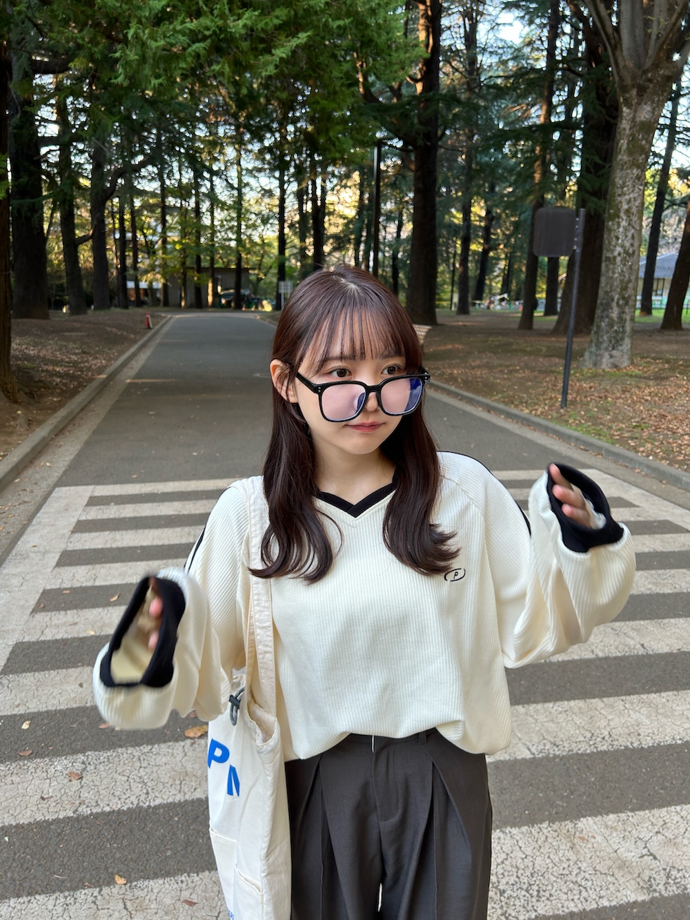 ホワイト系のスウェット、ホワイト系のトートバッグ、グレー系のスラックスを着用したレディースの冬コーディネートの5枚目の写真