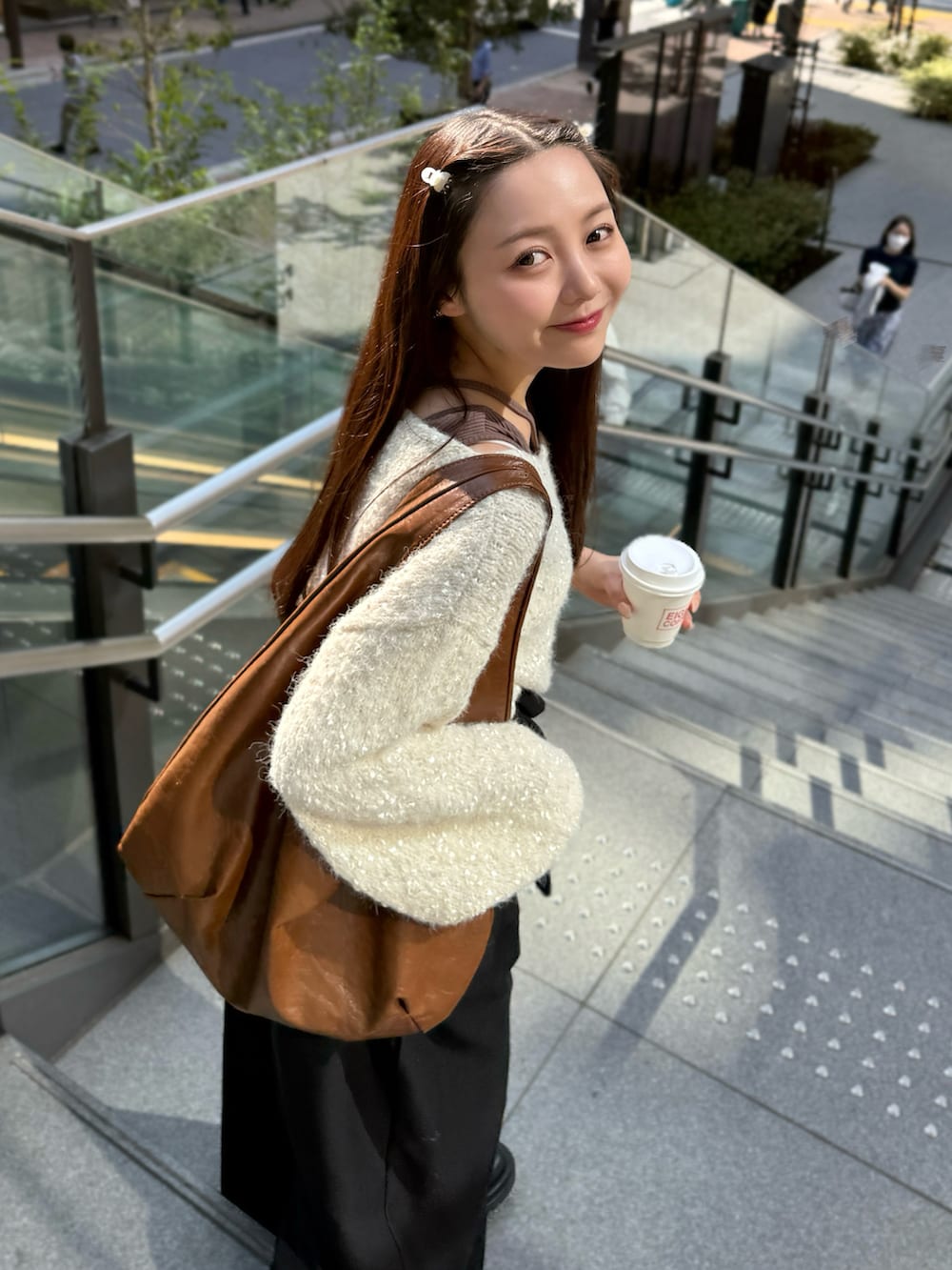 ベージュ系のニット/セーター、イエロー系のトートバッグ、ブラウン系のタンクトップを着用したレディースの秋コーディネートの2枚目の写真