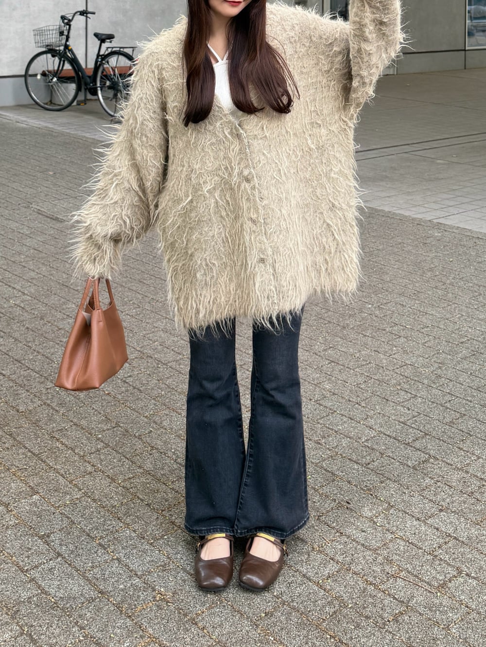 ブラック系のデニムパンツ、グリーン系のカーディガン/ボレロ、ベージュ系のタンクトップを着用したレディースの秋コーディネートの3枚目の写真