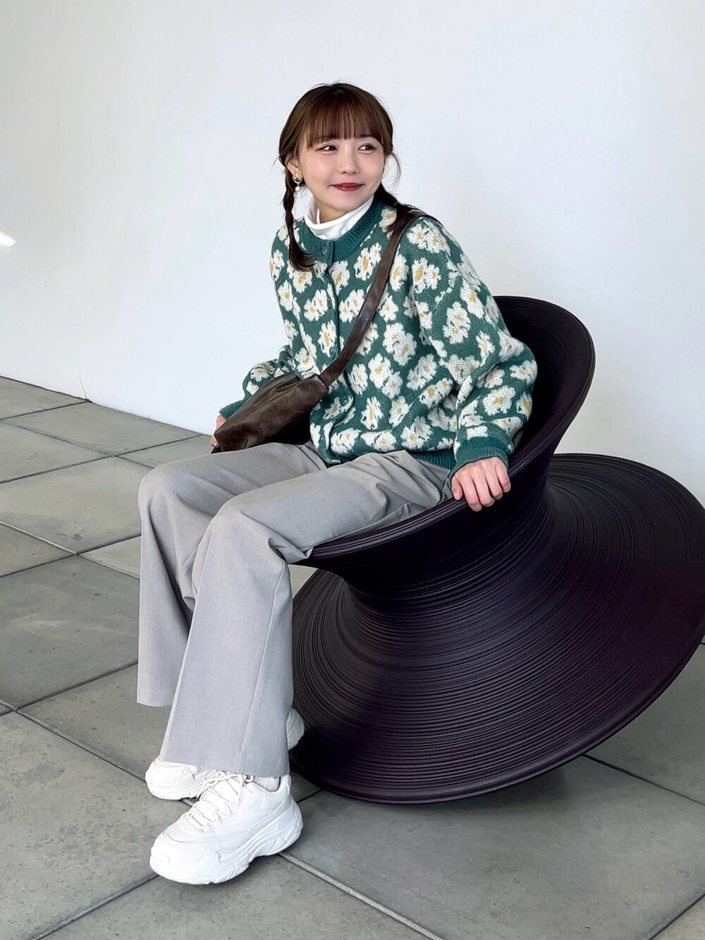 グリーン系のカーディガン/ボレロ、ベージュ系のパンツ、ホワイト系のスニーカーを着用したレディースの春コーディネートの5枚目の写真