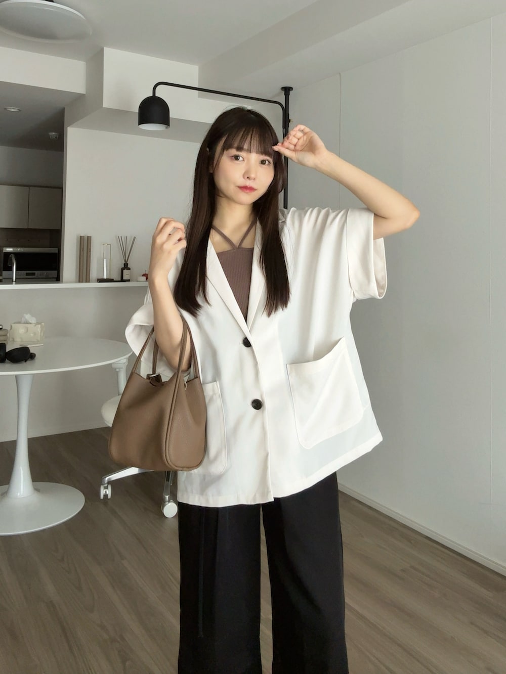 ホワイト系のテーラードジャケット、ブラック系のその他パンツ、ブラウン系のパンプスを着用したレディースの秋コーディネートの3枚目の写真