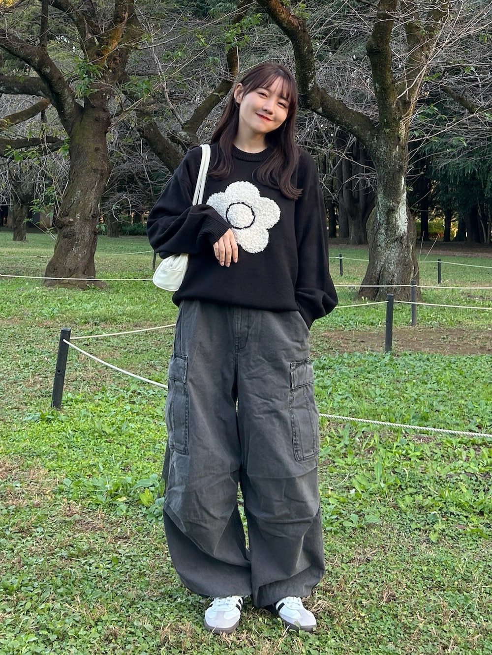 ブラック系のニット/セーター、ブラック系のブルゾン、グレー系のデニムパンツを着用したレディースの秋コーディネートの4枚目の写真