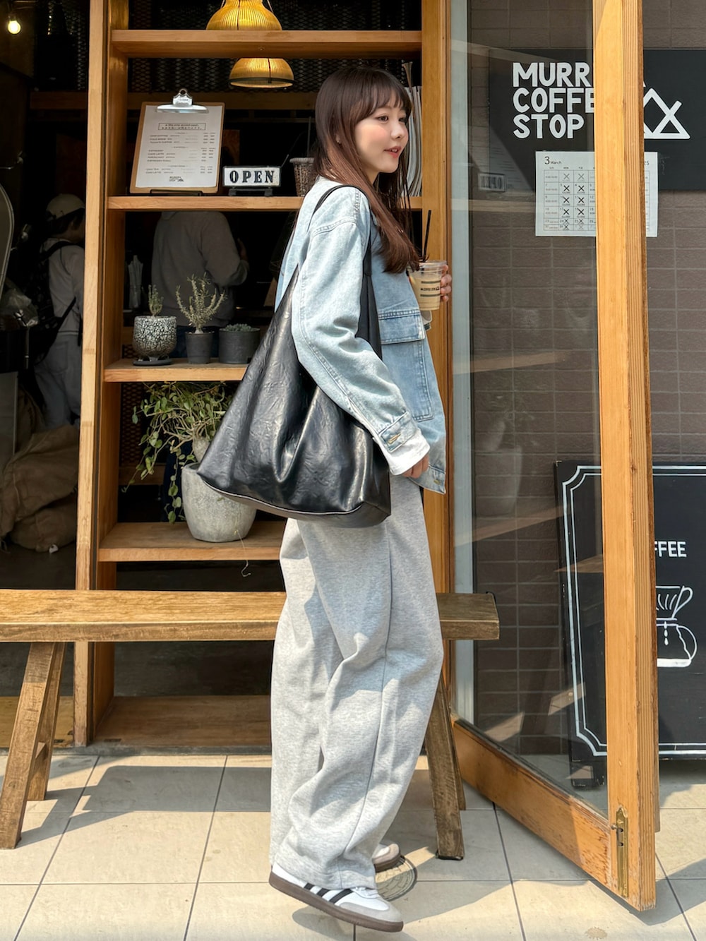 ホワイト系のTシャツ/カットソー、ブラック系のバッグ、グレー系のスウェットパンツを着用したレディースの春コーディネートの4枚目の写真