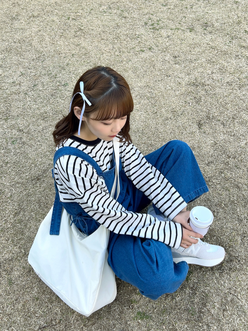 ホワイト系のTシャツ/カットソー、ホワイト系のショルダーバッグ、ブルー系のサロペット/オーバーオールを着用したレディースの春コーディネートの2枚目の写真