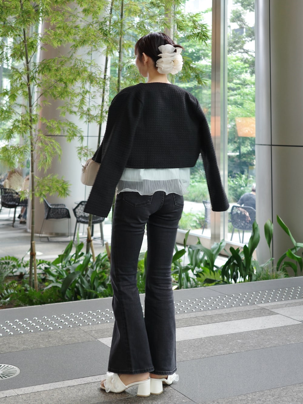ブルー系のキャミソール、ブラック系のデニムパンツ、ホワイト系のショルダーバッグを着用したレディースの夏コーディネートの3枚目の写真