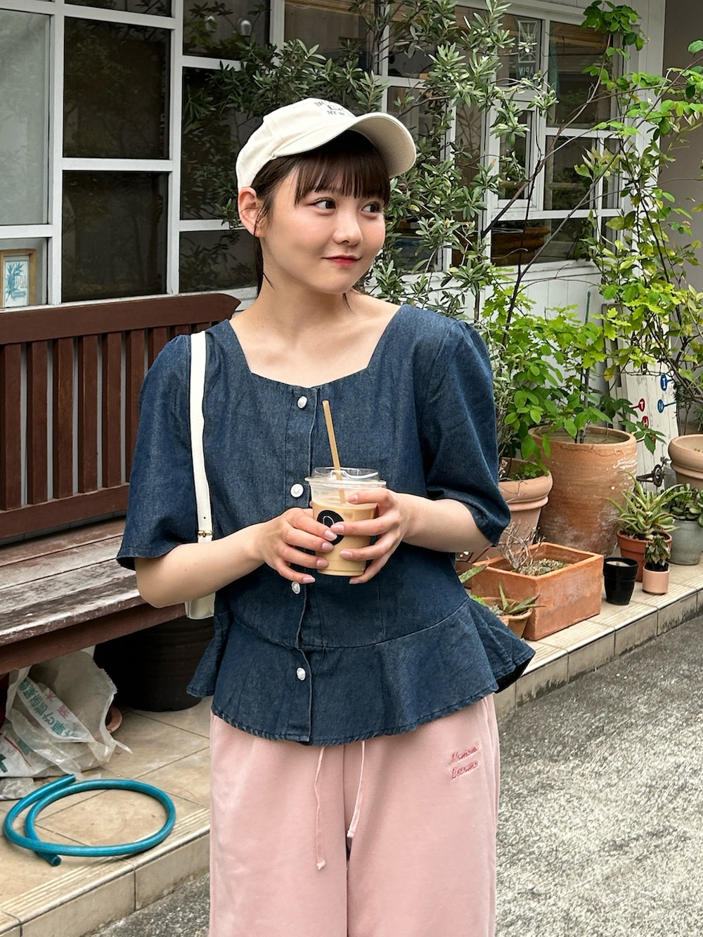 ブルー系のシャツ/ブラウス、ホワイト系のハンドバッグ、ピンク系のパンツを着用したレディースの春コーディネートの4枚目の写真