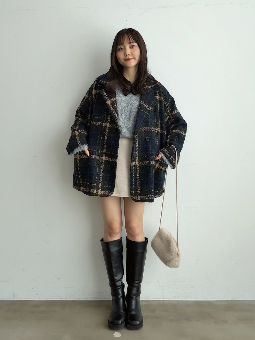 グレー系のニット/セーター、ホワイト系のスカート、ホワイト系のショルダーバッグを着用したレディースの冬コーディネートの3枚目の写真