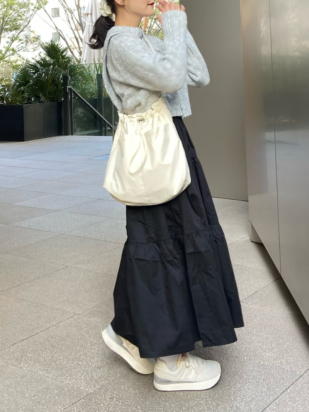 ブラック系のワンピース、グレー系のニット/セーター、ベージュ系のショルダーバッグを着用したレディースの春コーディネートの4枚目の写真