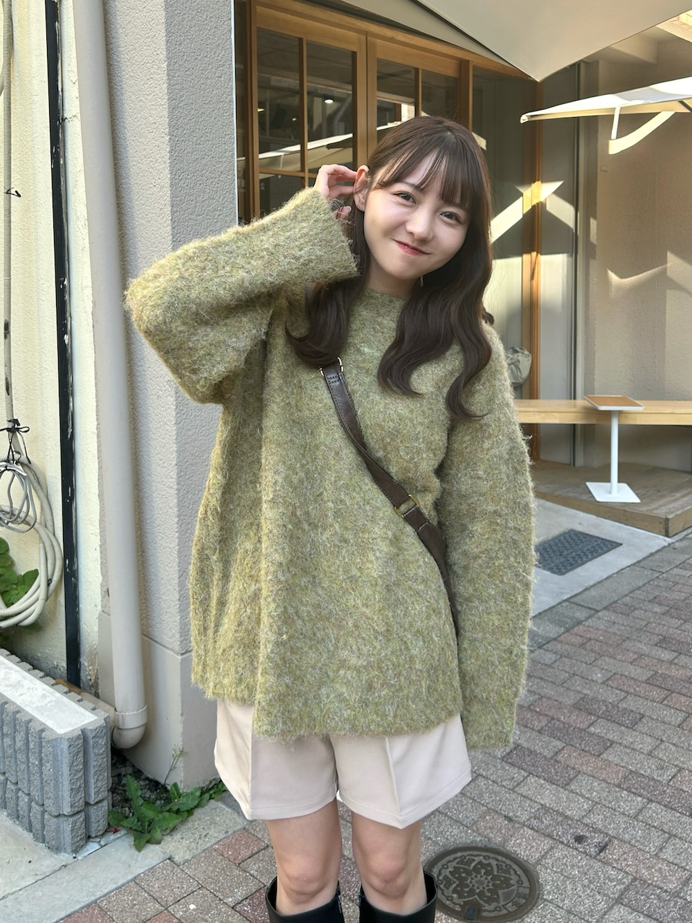 ブラウン系のショルダーバッグ、グリーン系のニット/セーター、ベージュ系のその他パンツを着用したレディースの秋コーディネートの2枚目の写真