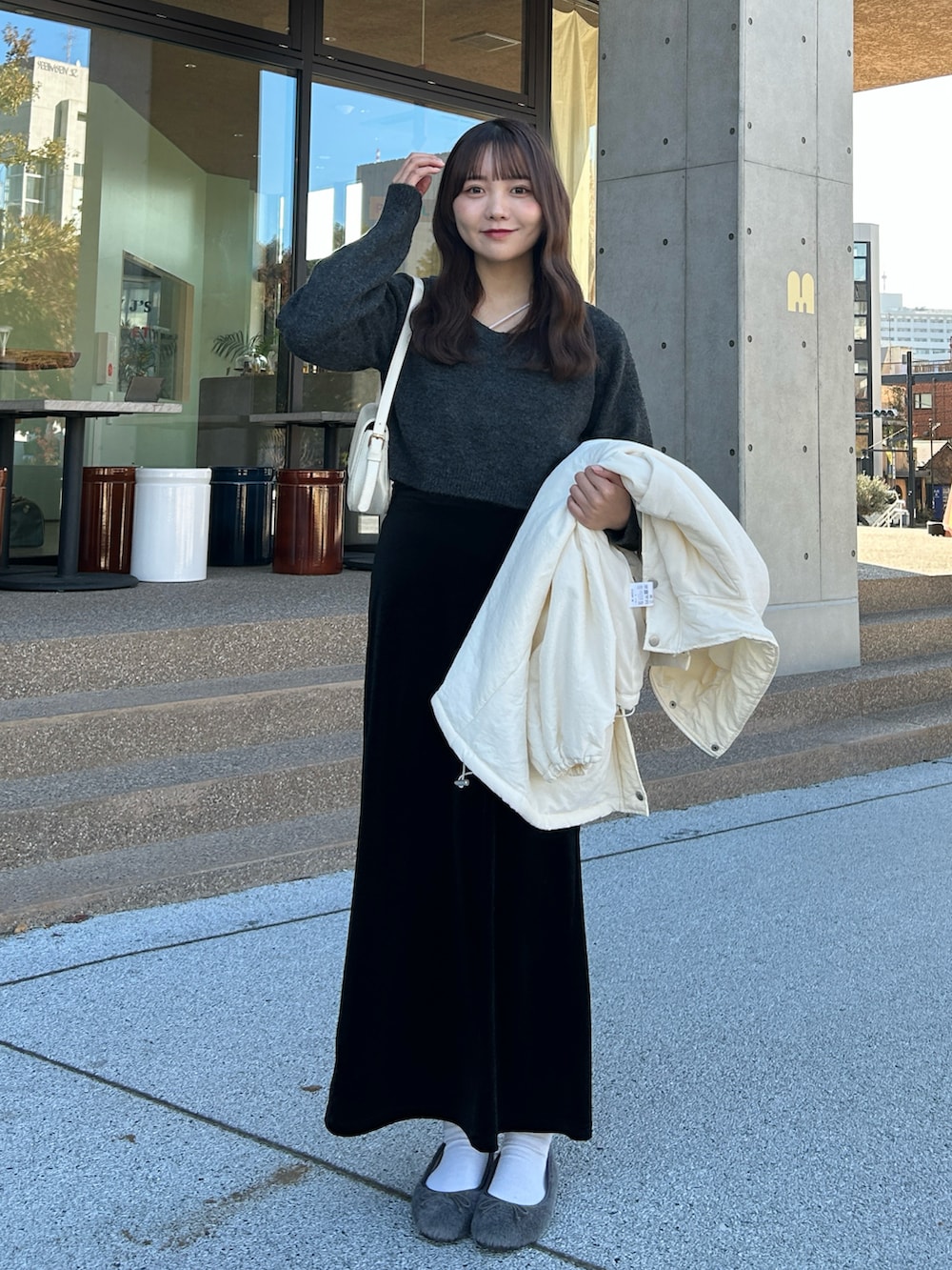 ホワイト系のキャミソール、グレー系のニット/セーター、ホワイト系のダウンジャケット/コートを着用したレディースの冬コーディネートの2枚目の写真