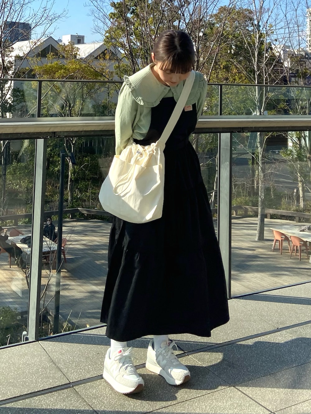 ブラック系のワンピース、ベージュ系のショルダーバッグ、グリーン系のシャツ/ブラウスを着用したレディースの春コーディネートの4枚目の写真
