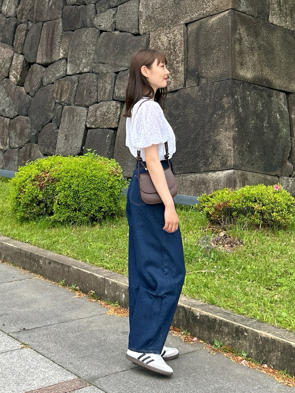 ホワイト系のシャツ/ブラウス、ブラウン系のショルダーバッグ、ブルー系のデニムパンツを着用したレディースの春コーディネートの3枚目の写真