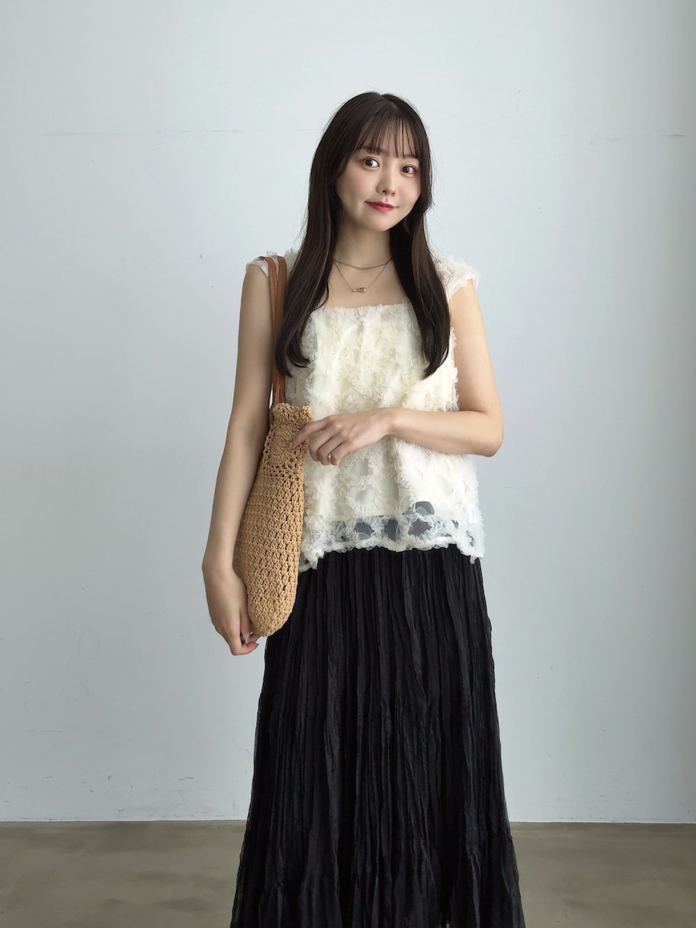 ブラック系のスカート、ブラック系のサンダル、ホワイト系のシャツ/ブラウスを着用したレディースの夏コーディネートの3枚目の写真