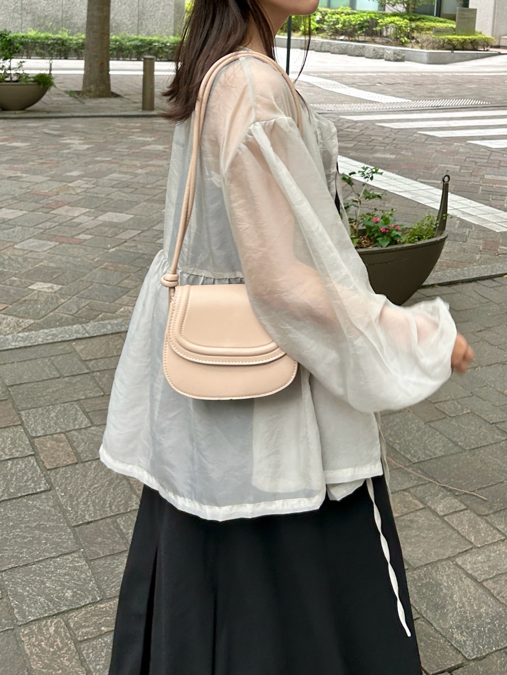 ベージュ系のトップス、ホワイト系のキャミソール、ブラック系のワンピースを着用したレディースの夏コーディネートの3枚目の写真