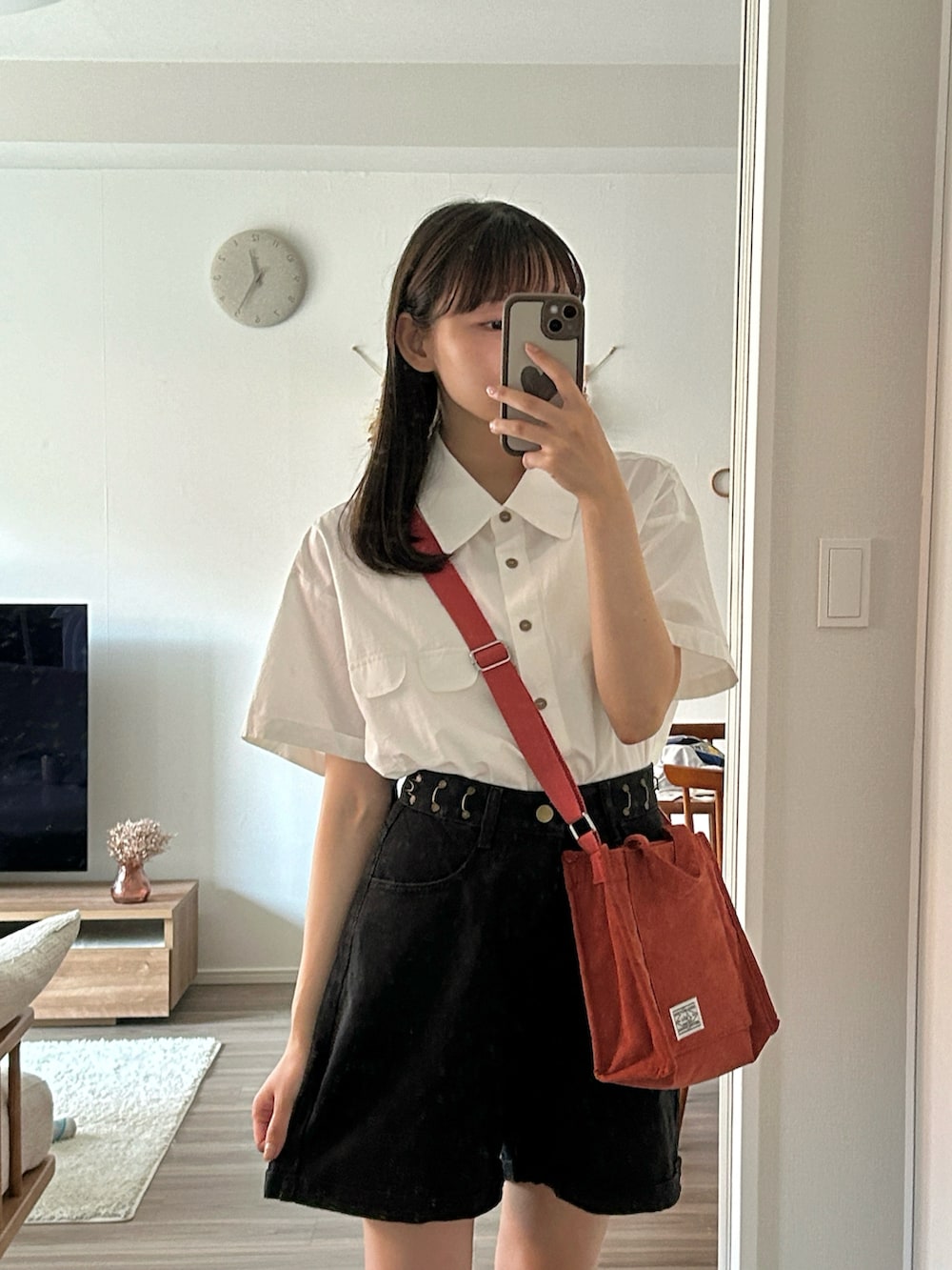 レッド系のショルダーバッグ、ベージュ系のサンダル、ホワイト系のシャツ/ブラウスを着用したレディースの夏コーディネートの5枚目の写真