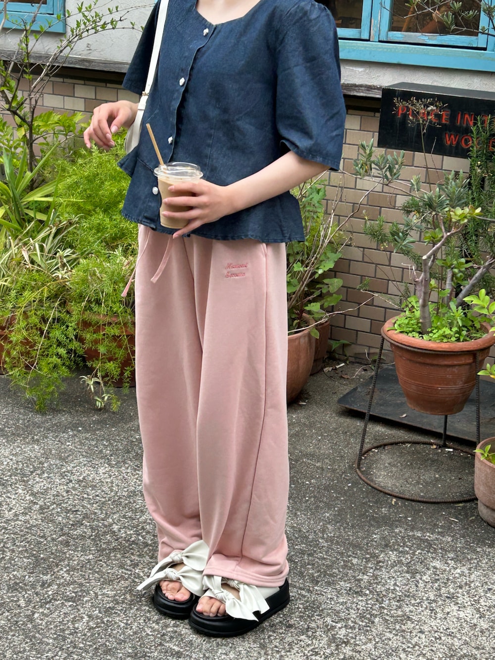 ブルー系のシャツ/ブラウス、ホワイト系のハンドバッグ、ピンク系のパンツを着用したレディースの春コーディネートの2枚目の写真