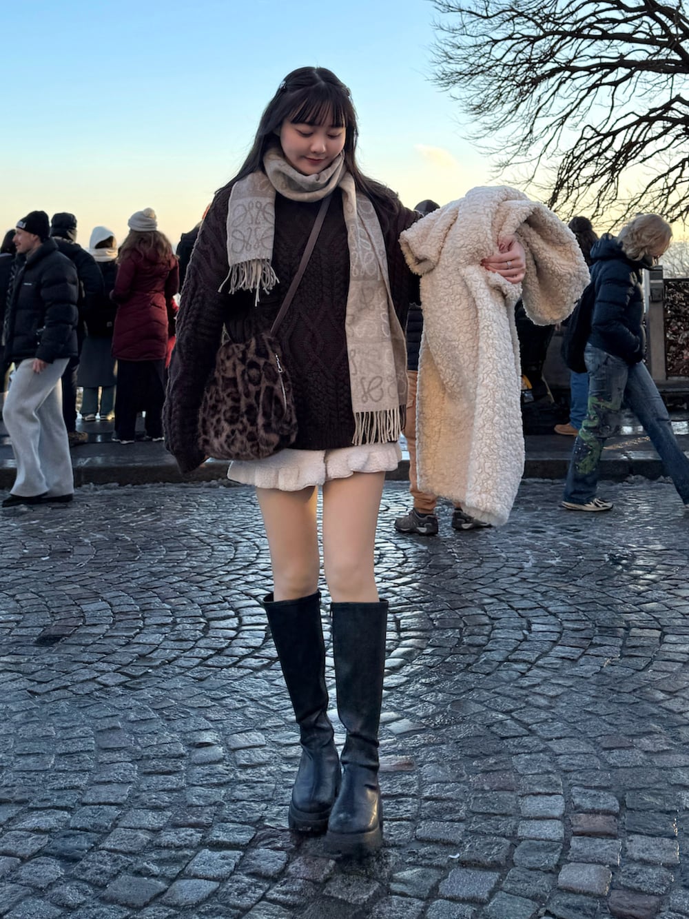 ブラウン系のニット/セーター、ブラウン系のショルダーバッグ、ベージュ系のその他アウターを着用したレディースの冬コーディネートの3枚目の写真