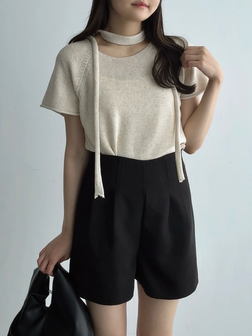 ベージュ系のTシャツ/カットソー、ブラック系のハンドバッグ、ブラック系のその他パンツを着用したレディースの夏コーディネートの3枚目の写真