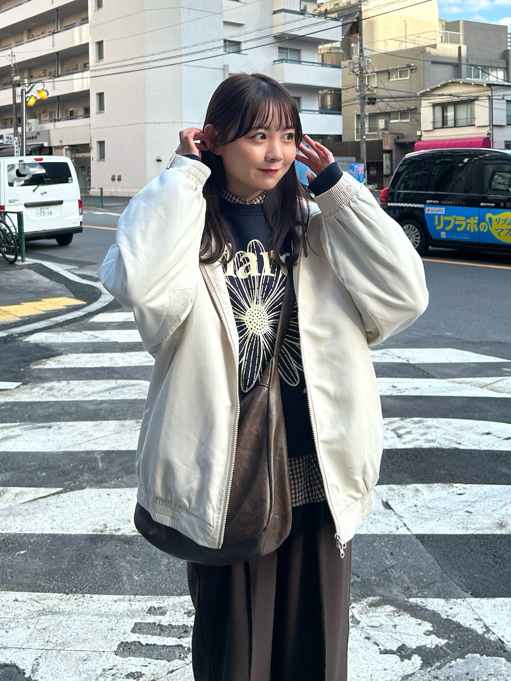 ブルー系のスウェット、ベージュ系のブルゾン、ブラウン系のパンツを着用したレディースの秋コーディネートの2枚目の写真