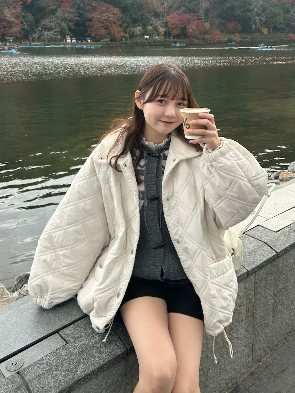 ホワイト系のブルゾン、グレー系のニット/セーター、ホワイト系のTシャツ/カットソーを着用したレディースの冬コーディネートの3枚目の写真