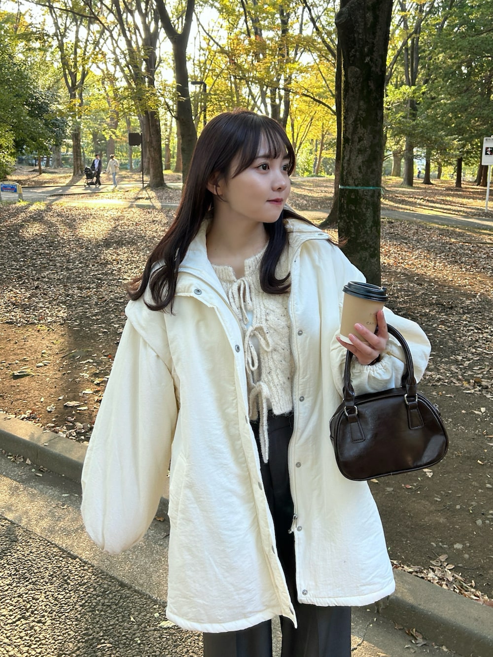 ベージュ系のカーディガン/ボレロ、ホワイト系のキャミソール、ホワイト系のダウンジャケット/コートを着用したレディースの冬コーディネートの4枚目の写真