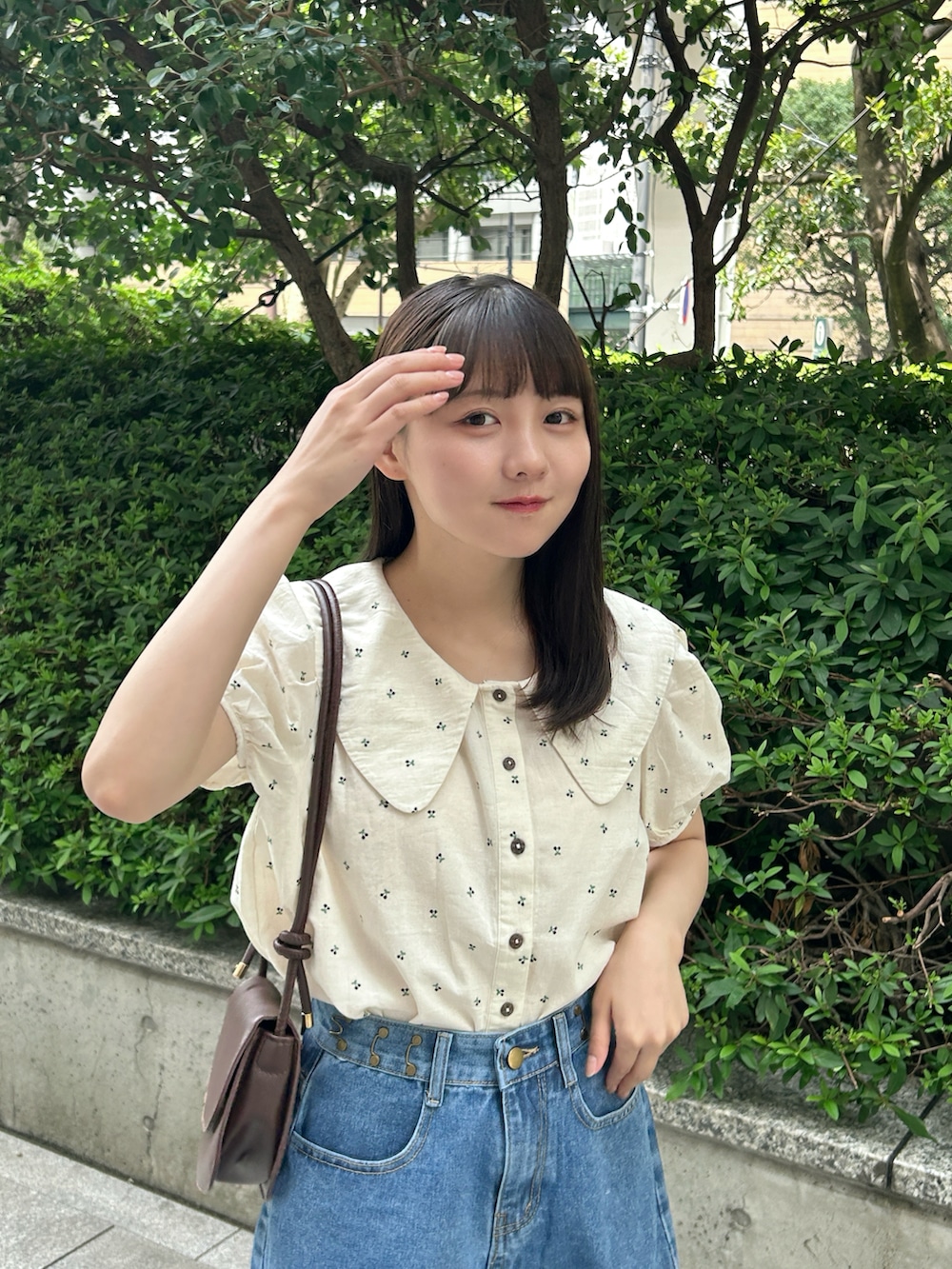 ブルー系のシャツ/ブラウス、ブルー系のデニムパンツ、ブラウン系のハンドバッグを着用したレディースの夏コーディネートの4枚目の写真