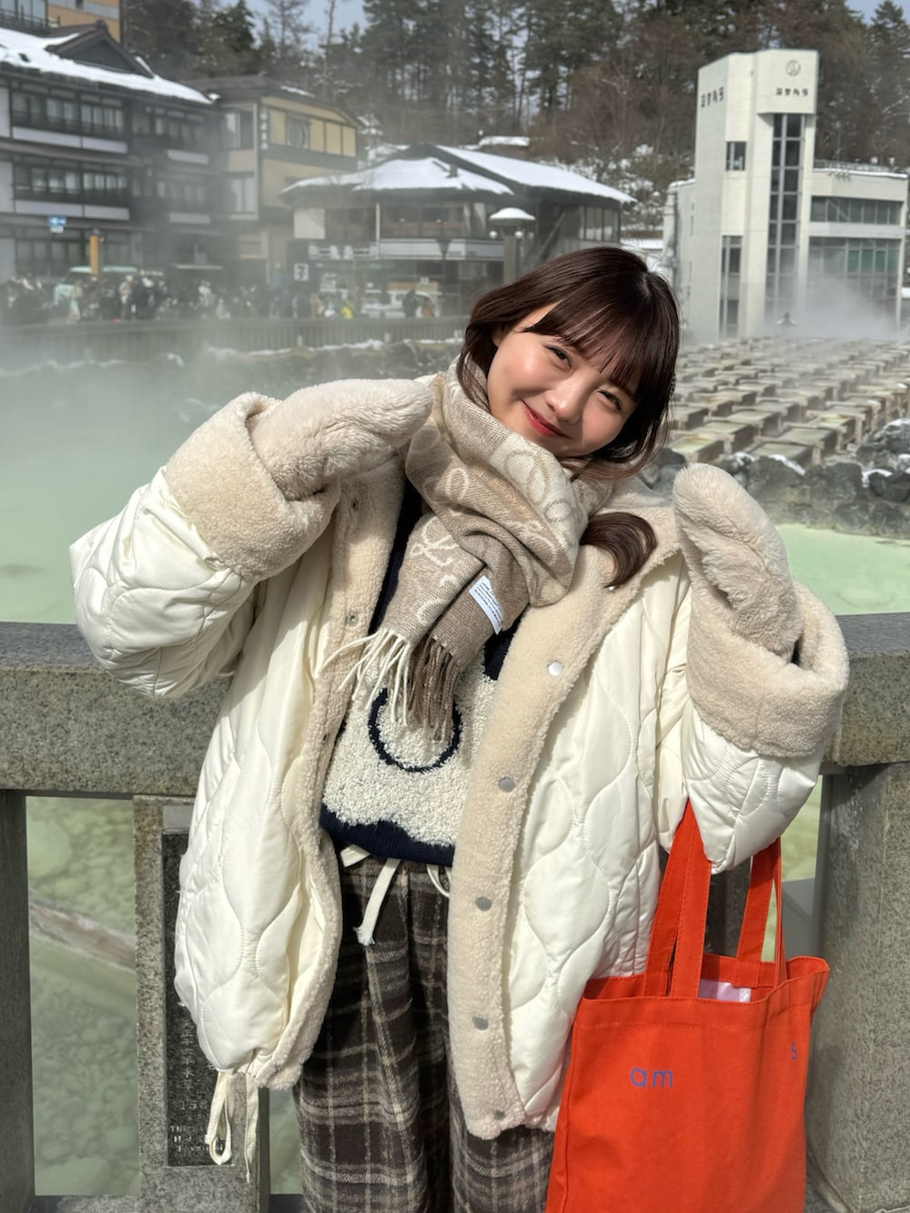 ホワイト系のブルゾン、ブルー系のニット/セーター、ホワイト系のトップスを着用したレディースの冬コーディネートの2枚目の写真