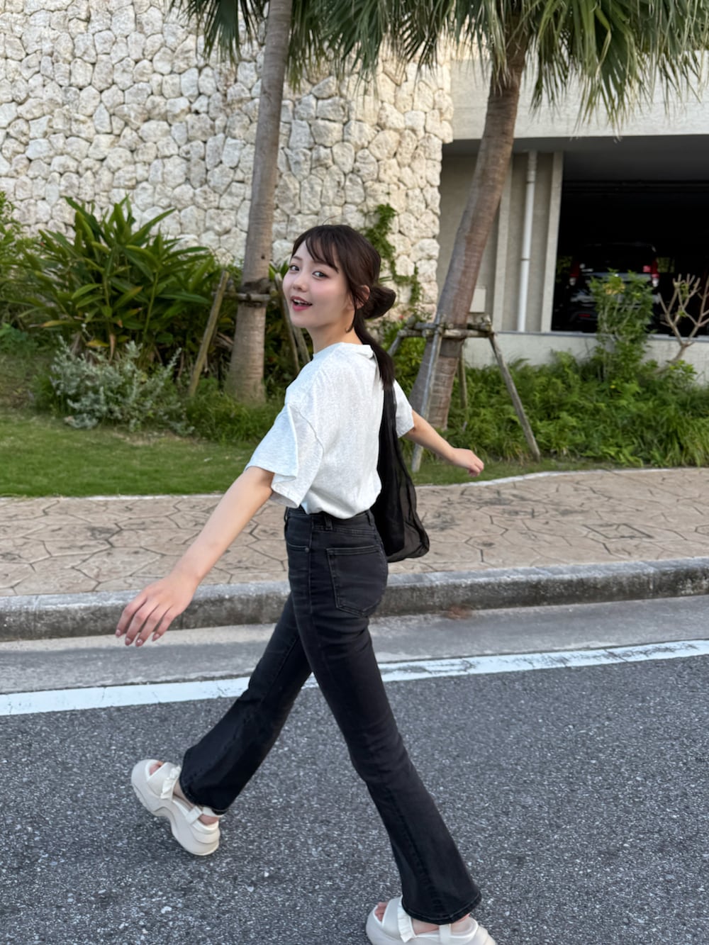 グレー系のTシャツ/カットソー、ブラック系のトートバッグ、ホワイト系のサンダルを着用したレディースの夏コーディネートの4枚目の写真