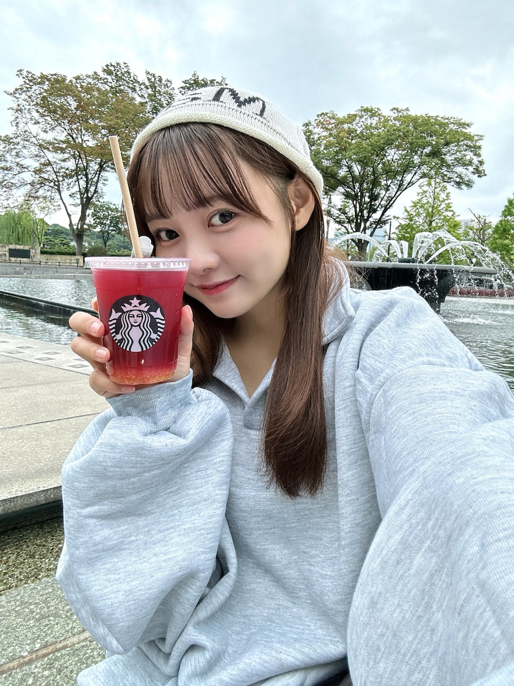 グレー系のスウェット、ホワイト系のバッグ、グレー系のスラックスを着用したレディースの秋コーディネートの3枚目の写真