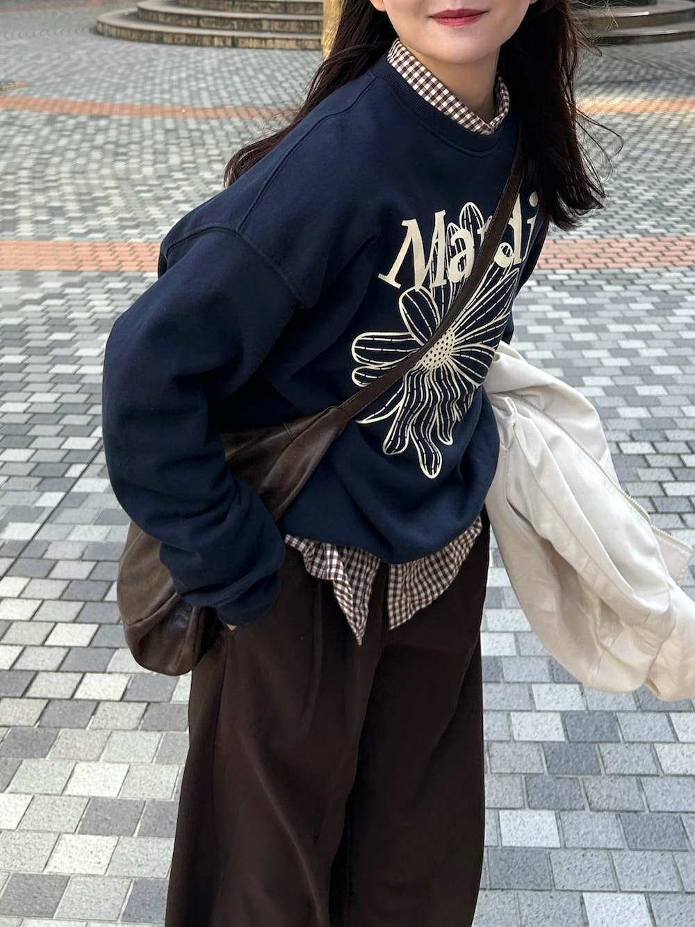 ブルー系のスウェット、ベージュ系のブルゾン、ブラウン系のパンツを着用したレディースの秋コーディネートの4枚目の写真