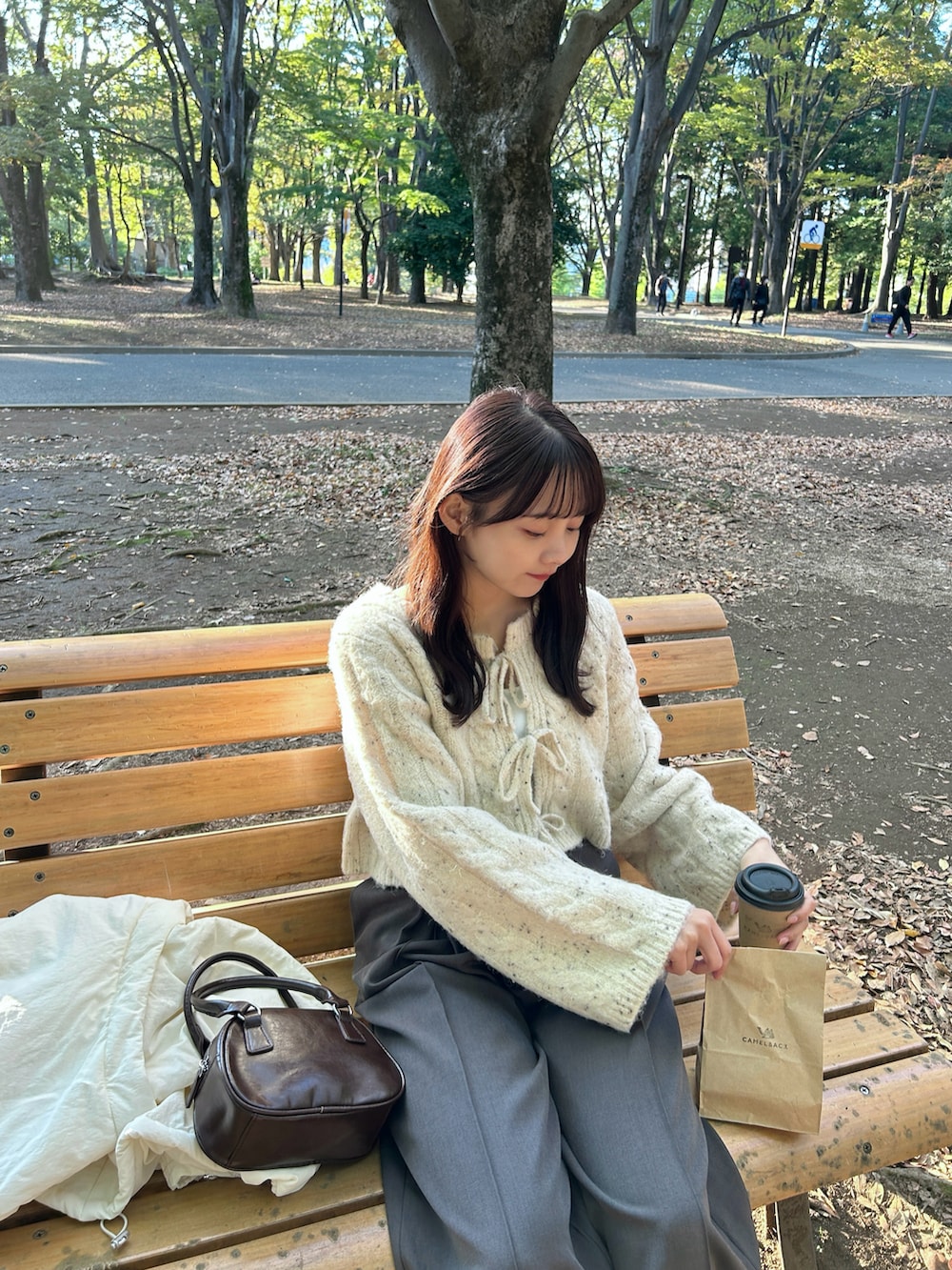 ベージュ系のカーディガン/ボレロ、ホワイト系のキャミソール、ホワイト系のダウンジャケット/コートを着用したレディースの冬コーディネートの3枚目の写真