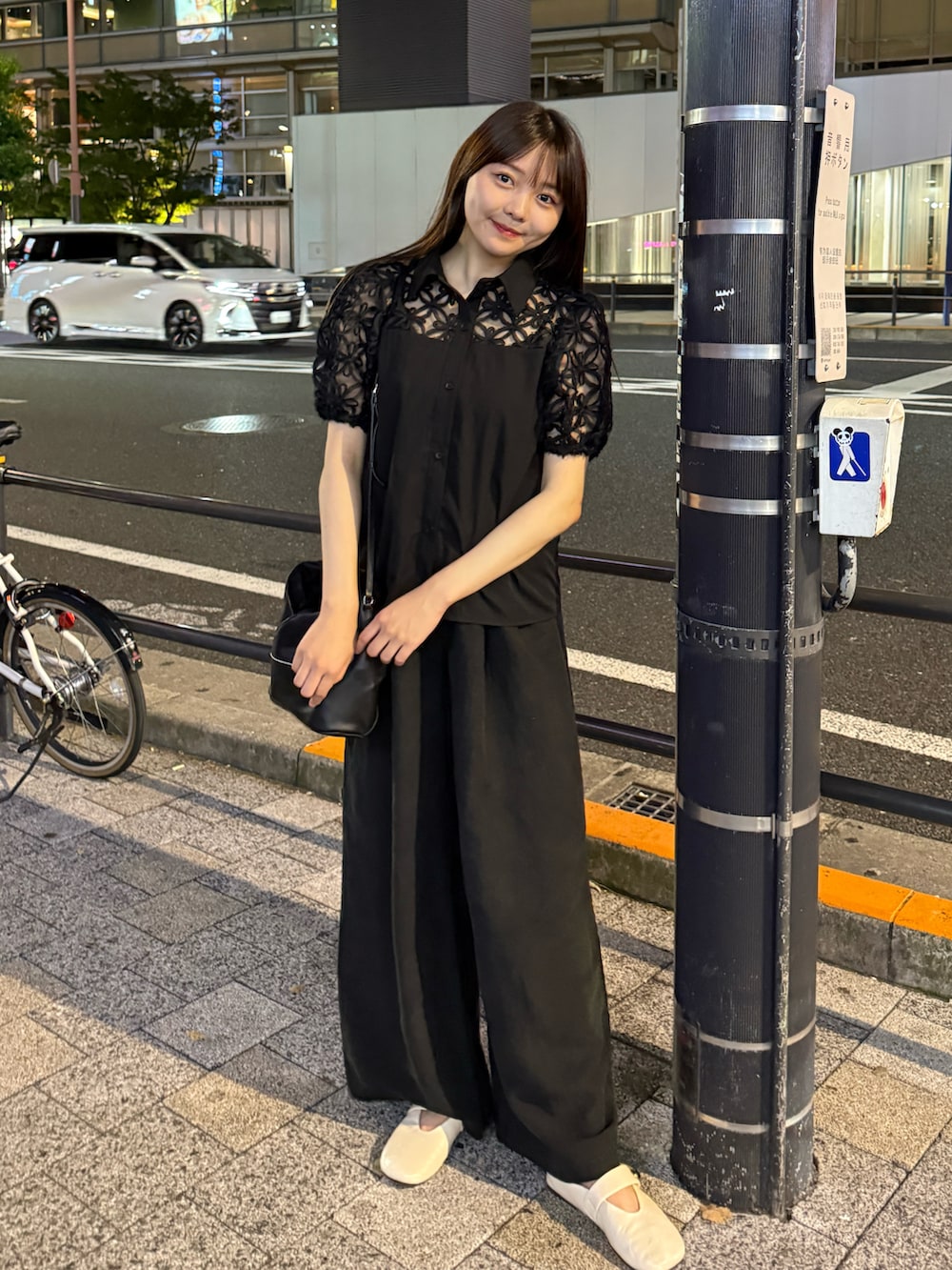 ブラック系のその他パンツ、ホワイト系のパンプス、ブラック系のショルダーバッグを着用したレディースの夏コーディネートの2枚目の写真