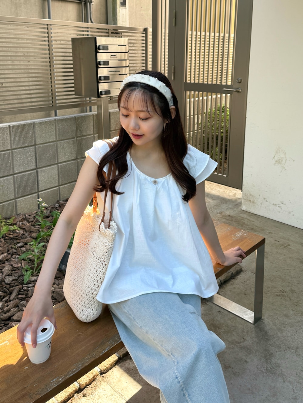 ホワイト系のシャツ/ブラウス、ホワイト系のトートバッグ、ブラウン系のパンプスを着用したレディースの夏コーディネートの4枚目の写真