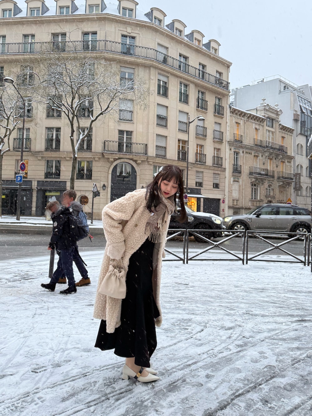 ベージュ系のその他アウター、ブラック系のワンピース、ホワイト系のパンプスを着用したレディースの冬コーディネートの5枚目の写真