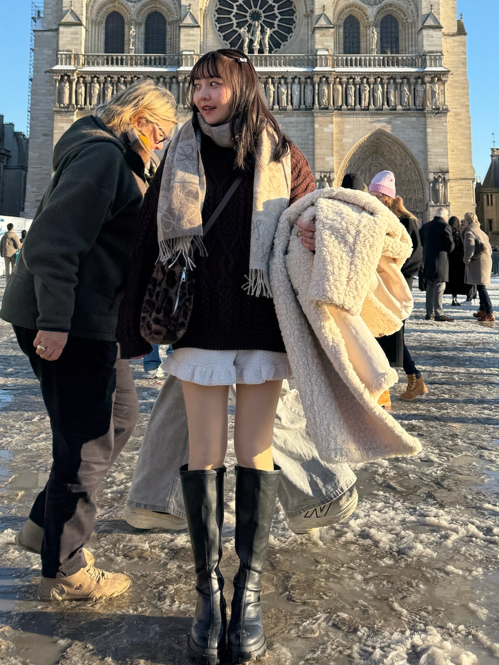 ブラウン系のニット/セーター、ブラウン系のショルダーバッグ、ベージュ系のその他アウターを着用したレディースの冬コーディネートの4枚目の写真