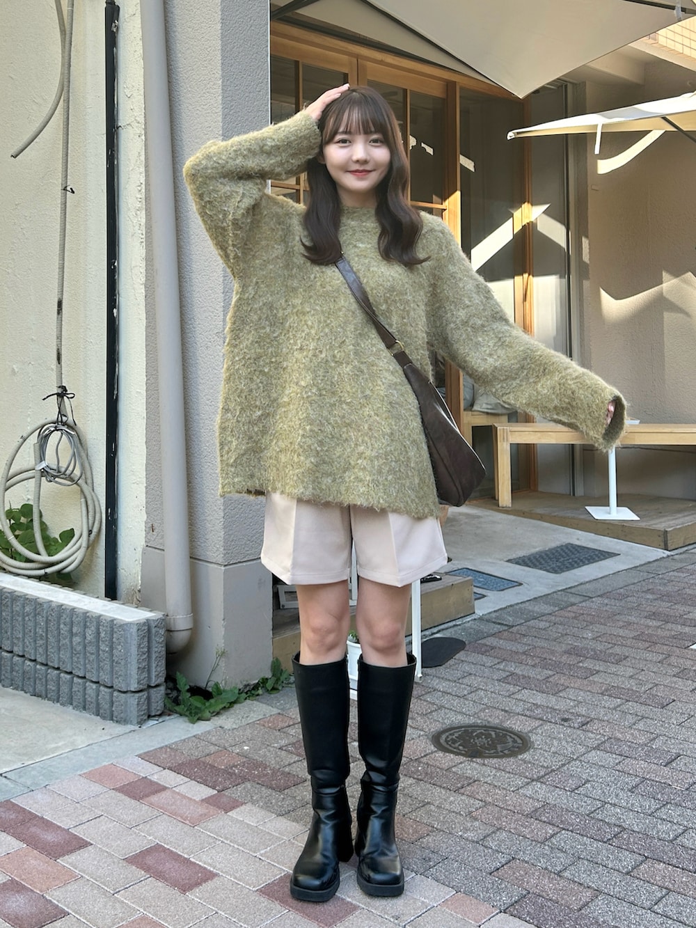 ブラウン系のショルダーバッグ、グリーン系のニット/セーター、ベージュ系のその他パンツを着用したレディースの秋コーディネートの3枚目の写真