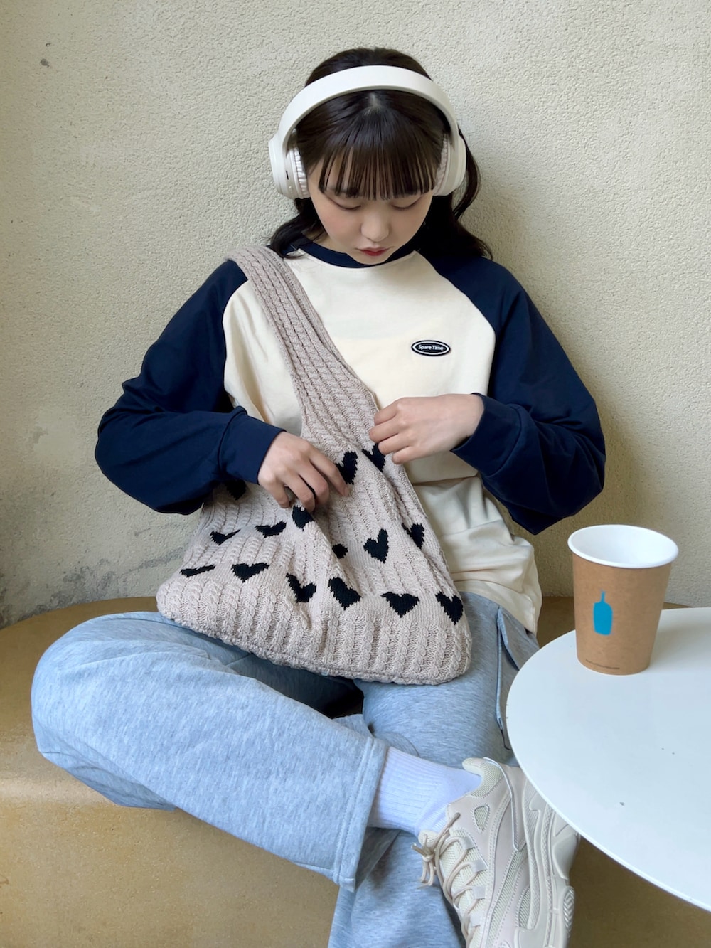 ベージュ系のTシャツ/カットソー、ベージュ系のトートバッグ、ホワイト系のスニーカーを着用したレディースの春コーディネートの3枚目の写真