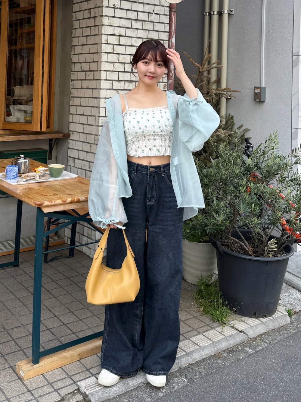 グリーン系のキャミソール、グリーン系のシャツ/ブラウス、イエロー系のハンドバッグを着用したレディースの春コーディネートの2枚目の写真