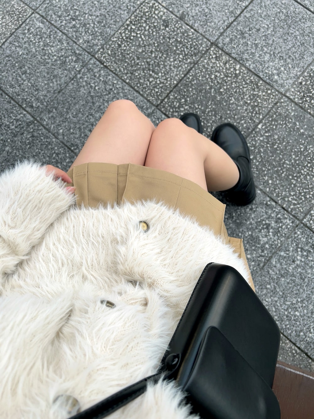 ブラック系のブーツ、ベージュ系のスカート、ブラック系のショルダーバッグを着用したレディースの冬コーディネートの4枚目の写真