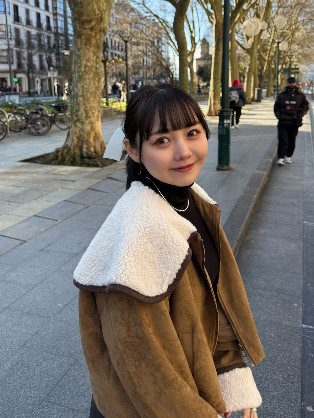 ブラック系のその他パンツ、イエロー系のブルゾン、ホワイト系のハンドバッグを着用したレディースの冬コーディネートの3枚目の写真