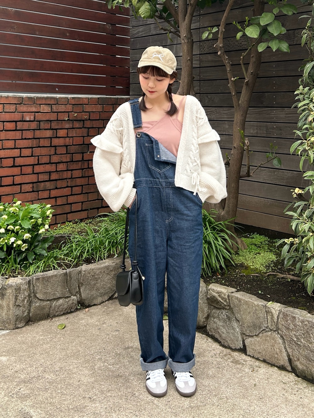 ピンク系のキャミソール、ブルー系のサロペット/オーバーオール、ホワイト系のスニーカーを着用したレディースの春コーディネートの4枚目の写真