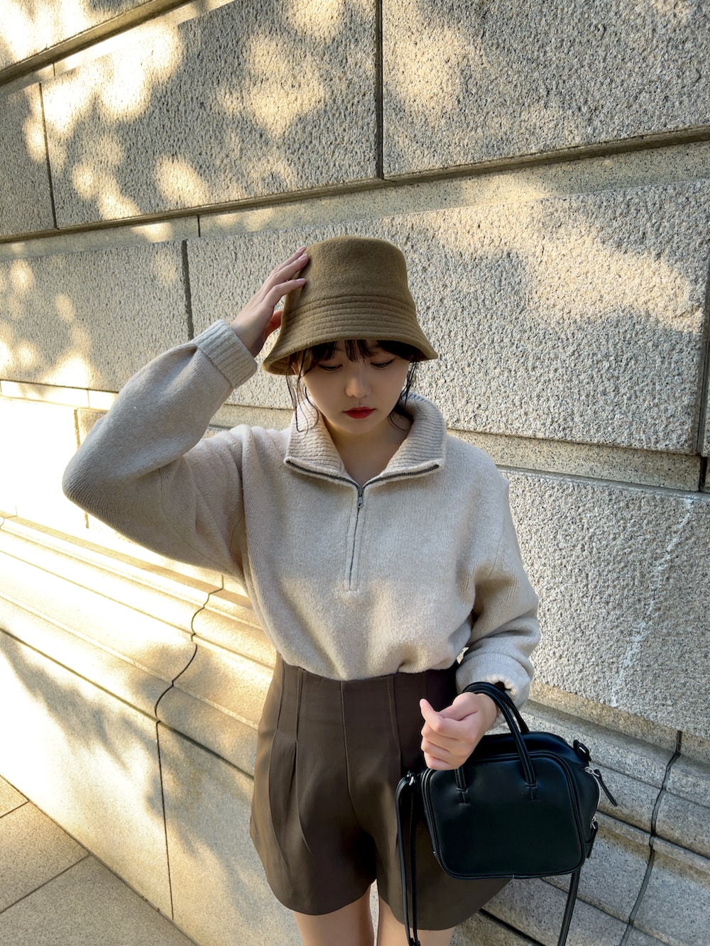 ホワイト系のブルゾン、ベージュ系のニット/セーター、ブラウン系のその他パンツを着用したレディースの冬コーディネートの4枚目の写真